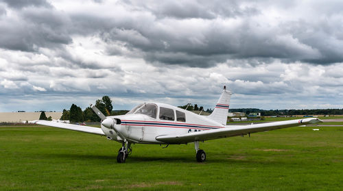 Airplane on airport runway against sky