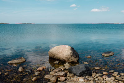 Rocks by sea against sky