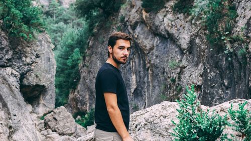 Portrait of young man standing on rock