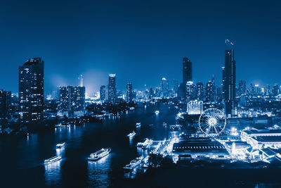 Illuminated buildings in city against sky at night