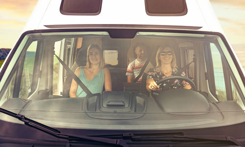 Front view through windshield of friends traveling in camper van