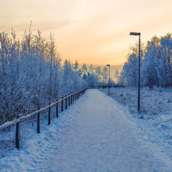 Snow covered road at sunset