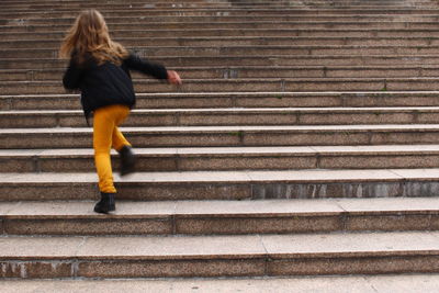 Rear view of girl walking on staircase