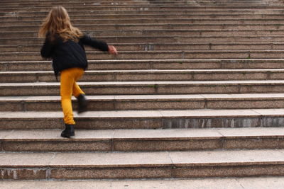 Rear view of woman walking on staircase