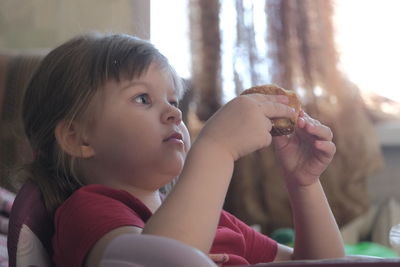 Close-up portrait of cute girl holding camera