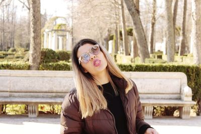 Portrait of smiling young woman against trees