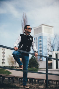 Full length of young man against railing