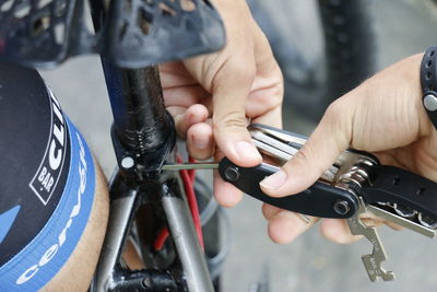 Close-up of persons hand fixing bicycle seat