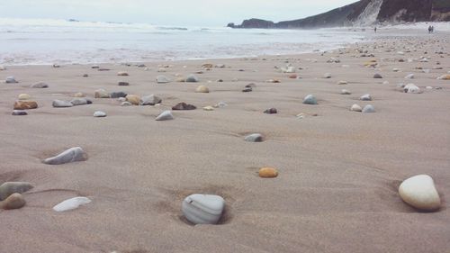 Pebbles on beach against sky