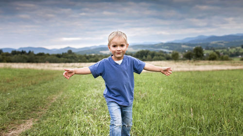 Portrait of happy boy standing on field