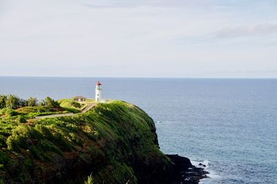 Lighthouse by sea against sky