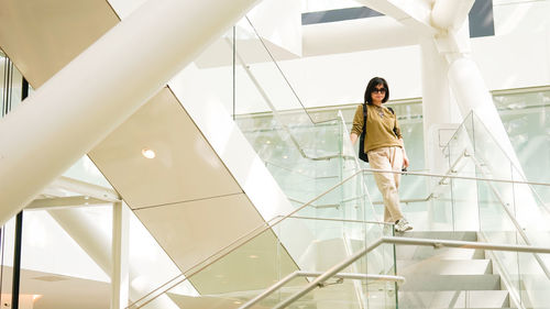 Low angle view of woman standing on staircase in building