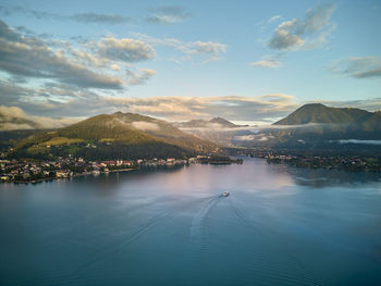 Sunset in the mountains with lake in the foreground and boat on the lake