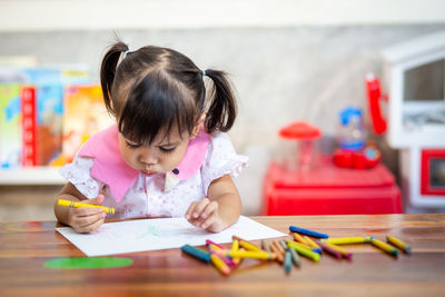 Portrait of cute girl sitting on table