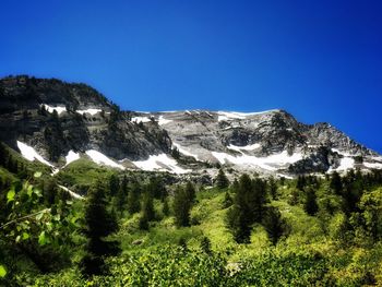 Scenic view of mountains against clear blue sky