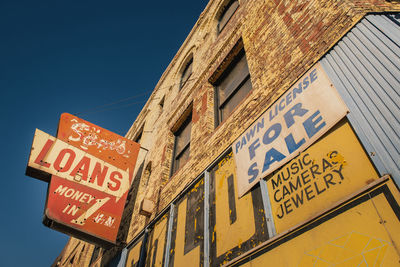 Low angle view of text on building against sky