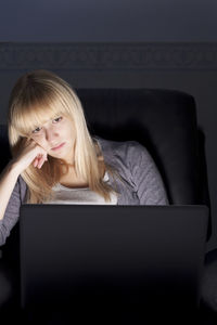 Young woman using laptop on mobile phone