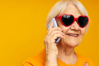 Smiling senior woman talking on phone against white background