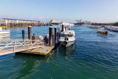 Boats moored in sea against clear sky