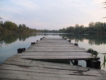 Wooden pier over lake against sky