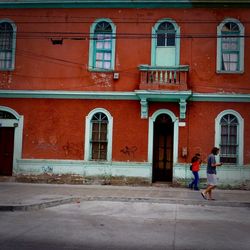 Rear view of woman walking on building in city