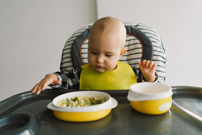 Little child with solid nutrition. baby girl eating food and mix vegetable plate