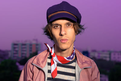 Portrait of man wearing hat against sky in city