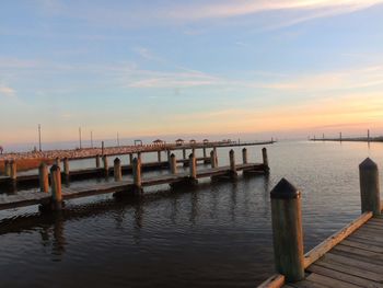 Pier over sea against sky during sunset