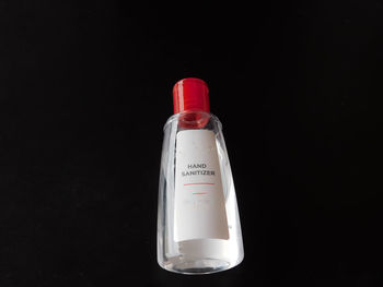 Close-up of glass bottle against black background