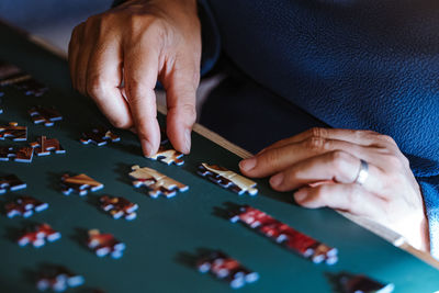 High angle view of woman playing with puzzle