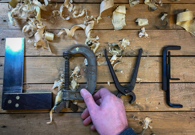 High angle view of hand holding tools on table