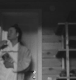 Portrait of woman standing against wall