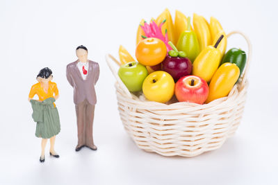 Fruits in basket against white background