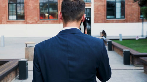 Rear view of man standing outside building