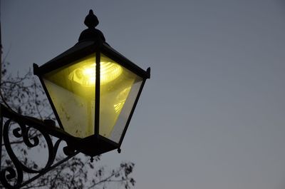 Low angle view of illuminated light bulb against sky