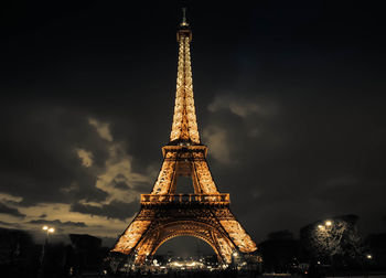 Communications tower in city against cloudy sky