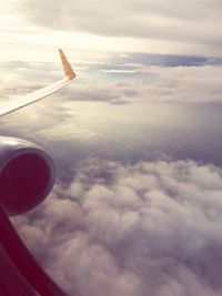 Cropped image of airplane flying over clouds