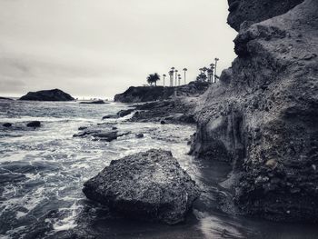 Rocks on beach against sky