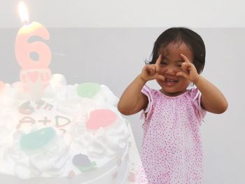 Digital composite image of girl by birthday cake