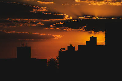 Silhouette buildings against sky during sunset