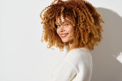 Portrait of young woman against white background