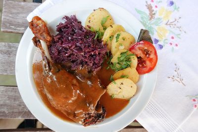High angle view of meat served by cabbage and potatoes in plate on table