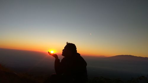 Silhouette man against sky during sunset