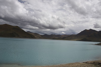 Scenic view of lake by mountains against sky