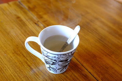 High angle view of coffee cup on wooden table