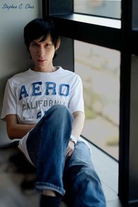 Full length of teenage boy sitting on wall