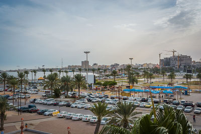 High angle view of swimming pool by cityscape against sky