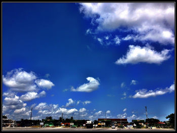 Panoramic view of city buildings against blue sky