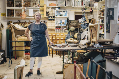 Portrait of female craftsperson standing in upholstery workshop