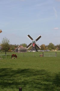 Traditional windmill on field against sky